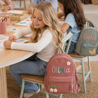 Two children in classroom with personalized name backpacks