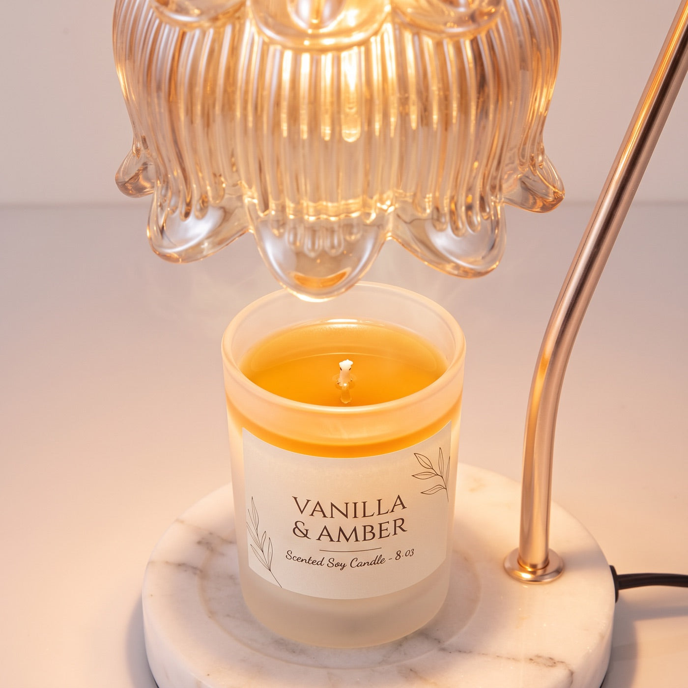 Warm light from the Marble Bloom shade melting a candle evenly with no flame