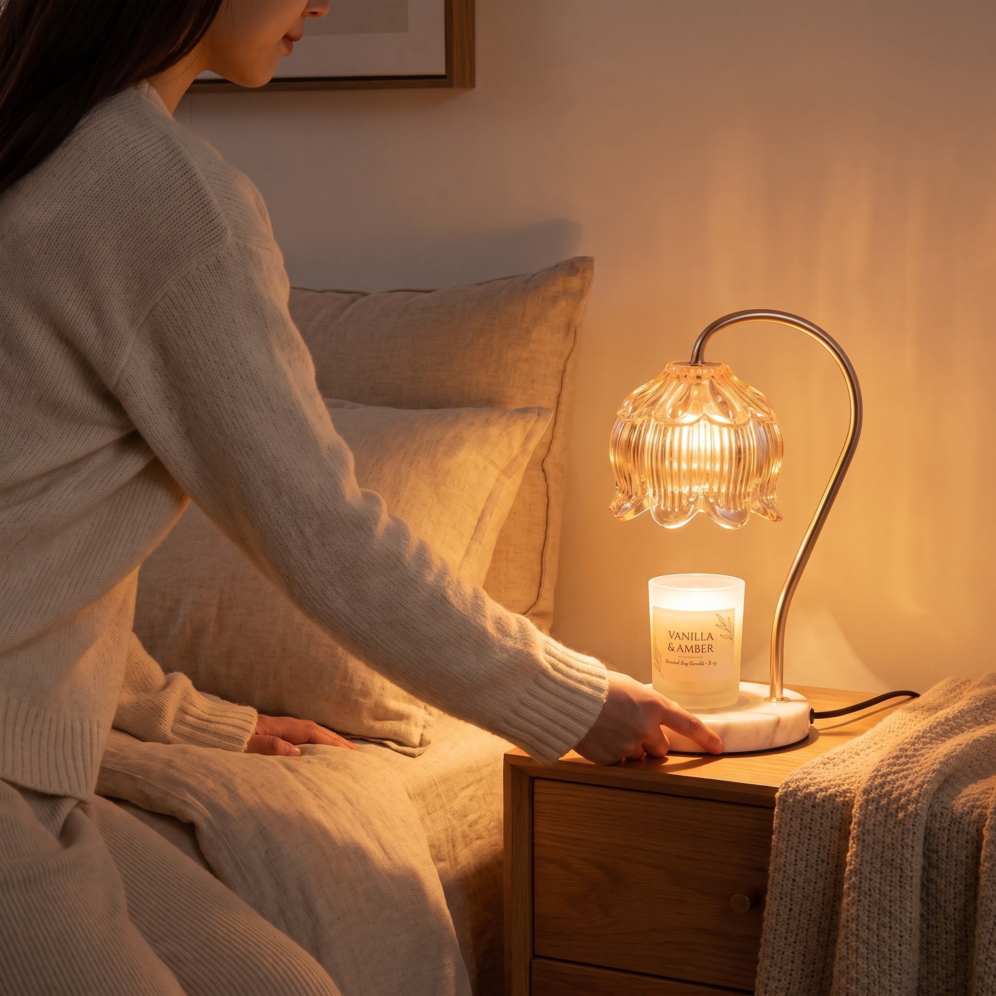 Woman placing the Marble Bloom candle warmer on a bedroom nightstand