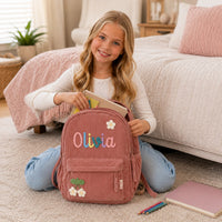 Girl packing school books into personalized backpack