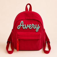Red corduroy backpack with Avery knitted in mint wool