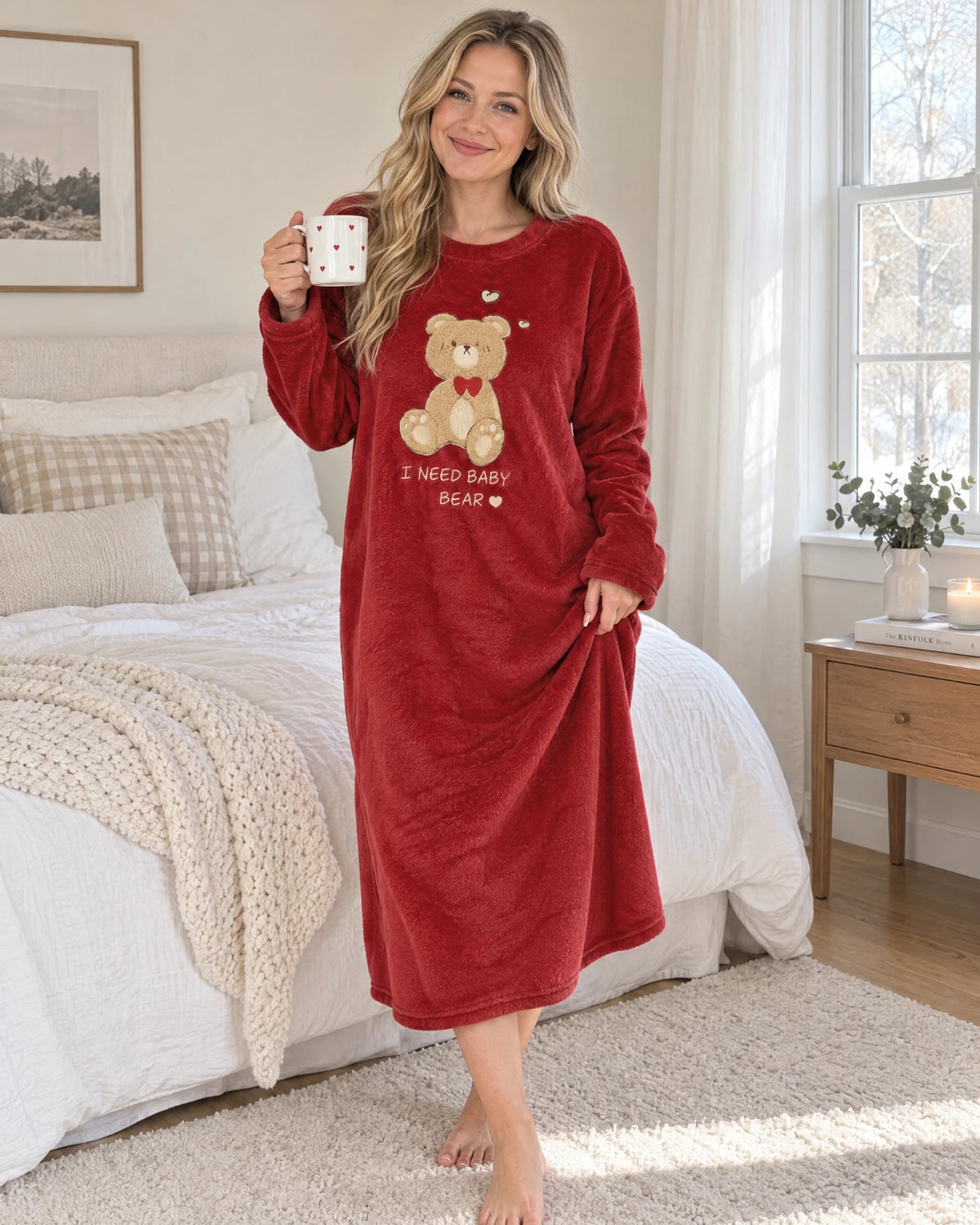 Woman holding a heart mug in the Bear Hug Fleece Nightgown, full length with the teddy bear and I NEED BABY BEAR stitching