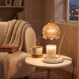Candle warmer lamp in a cozy reading nook beside a knit throw and tea