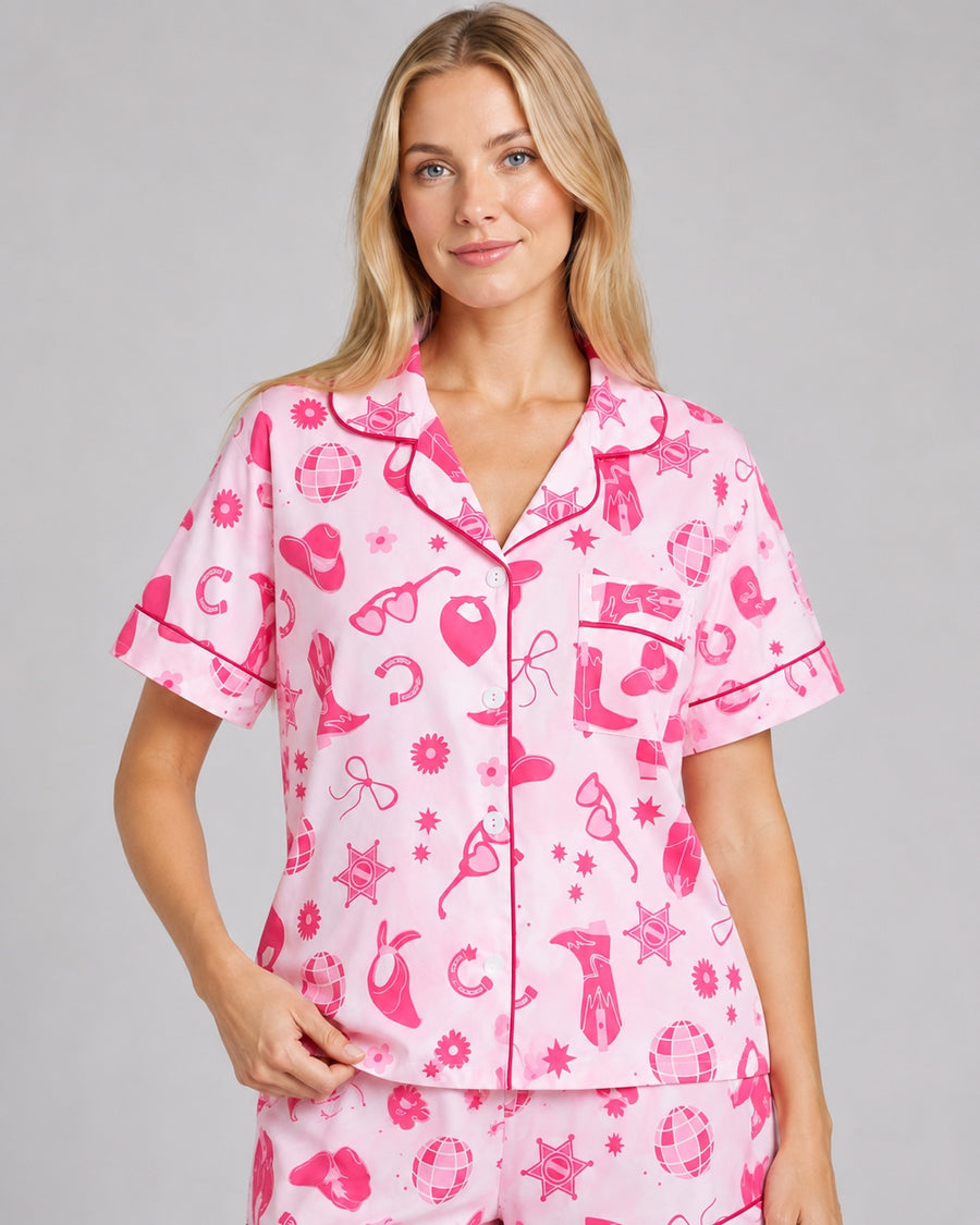 Closeup detail of pink cowgirl pajama print with sheriff stars heart sunglasses boots and magenta piping