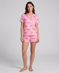Pink coquette ribbon-bow pajama set on model — front lifestyle view of stretch loungewear