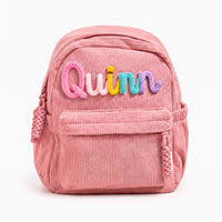 Pink corduroy backpack with Quinn knitted in bubblegum, blush, sunshine, turquoise and violet wool