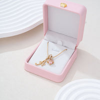 Gold initial A necklace presented in a pink gift box