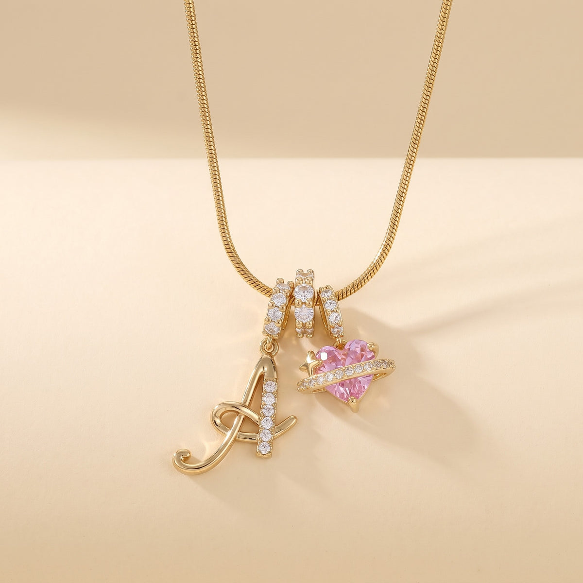 Gold script initial A necklace with pink heart charm