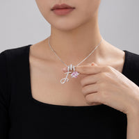 A young woman touching her silver initial J necklace