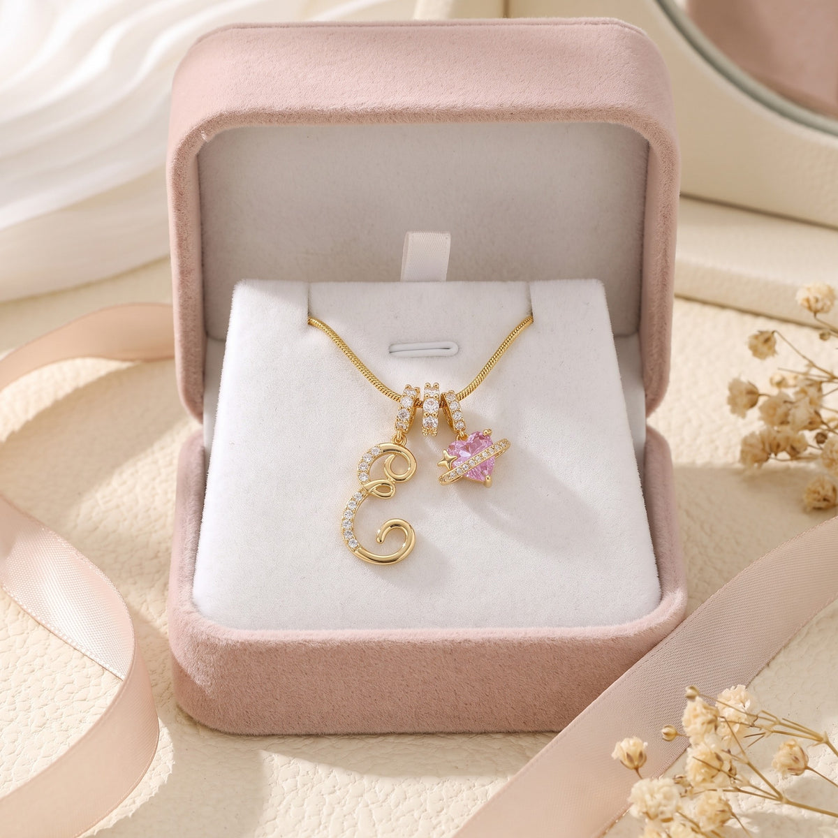 Gold initial E necklace in a pink gift box