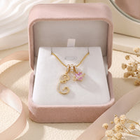 Gold initial E necklace in a pink gift box