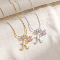 Gold and silver initial K necklaces side by side