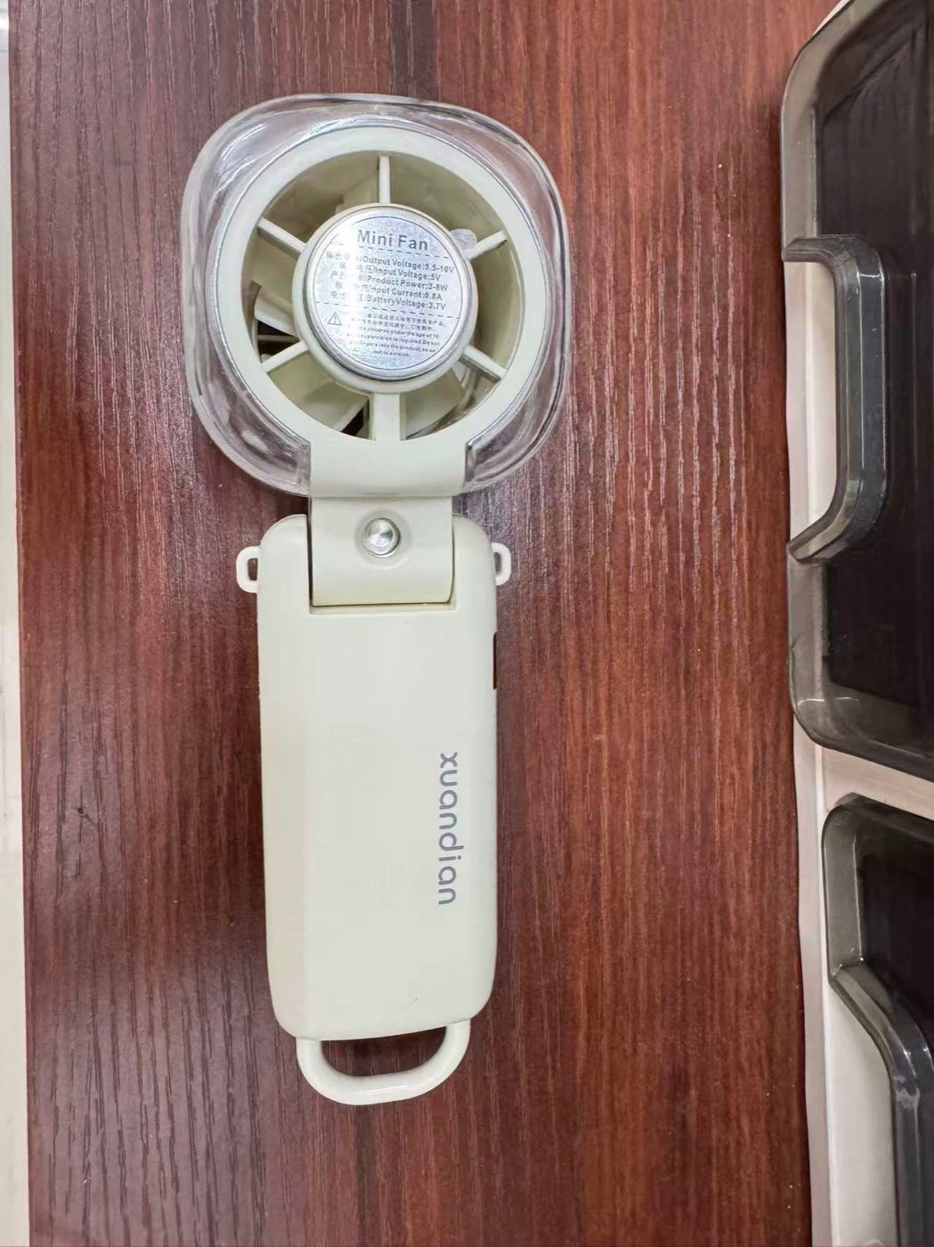 Customer photo — Beige Arctic Mist fan folded flat on desk