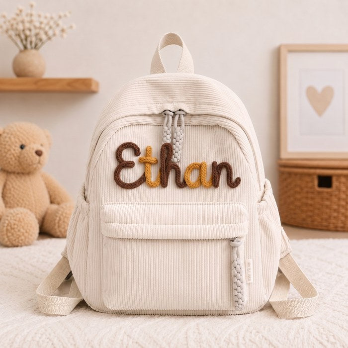 Ethan backpack, letters knitted in Chocolate A37 · Marigold A19